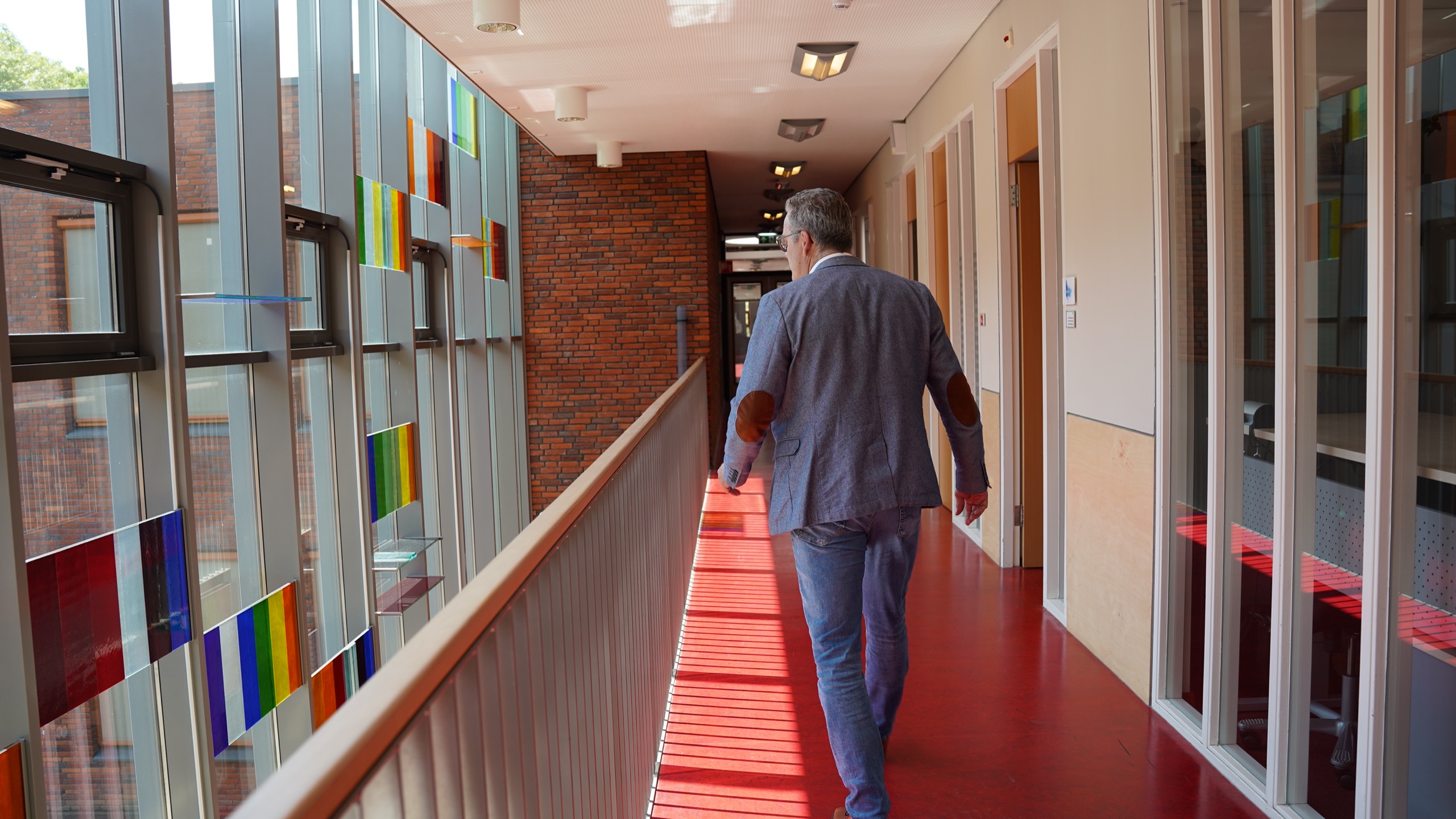 Erik van Faassen loopt door een schoolgang