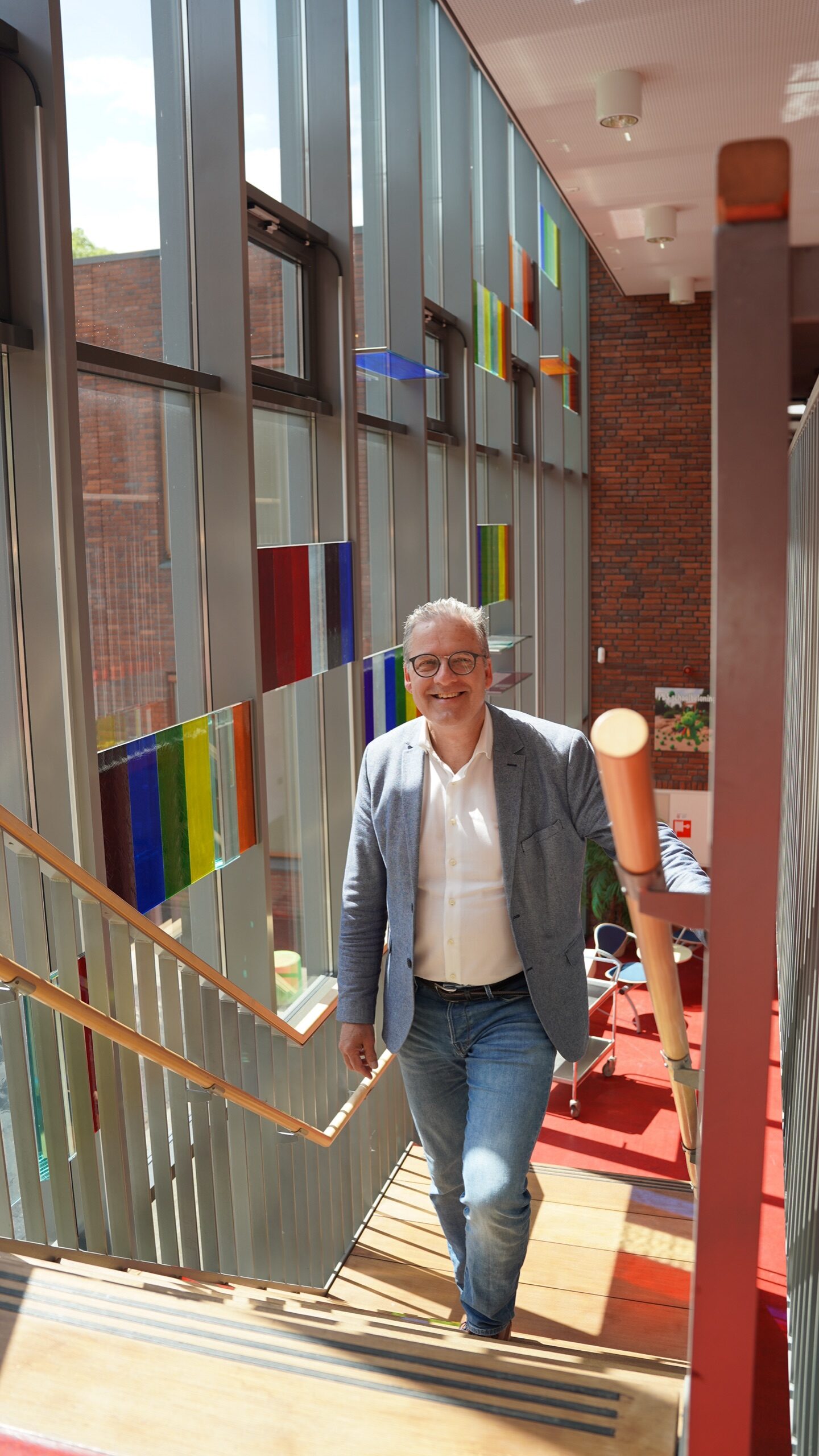 Erik van Faassen lachend op de trap in een school